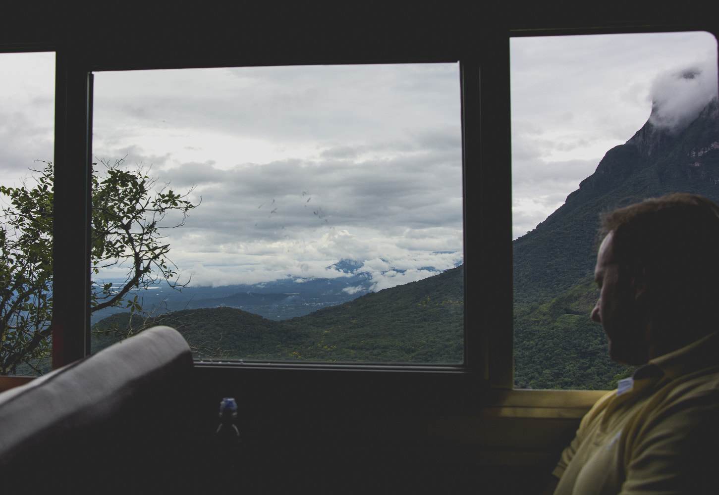 Cloud over green mountains, seen through a train window